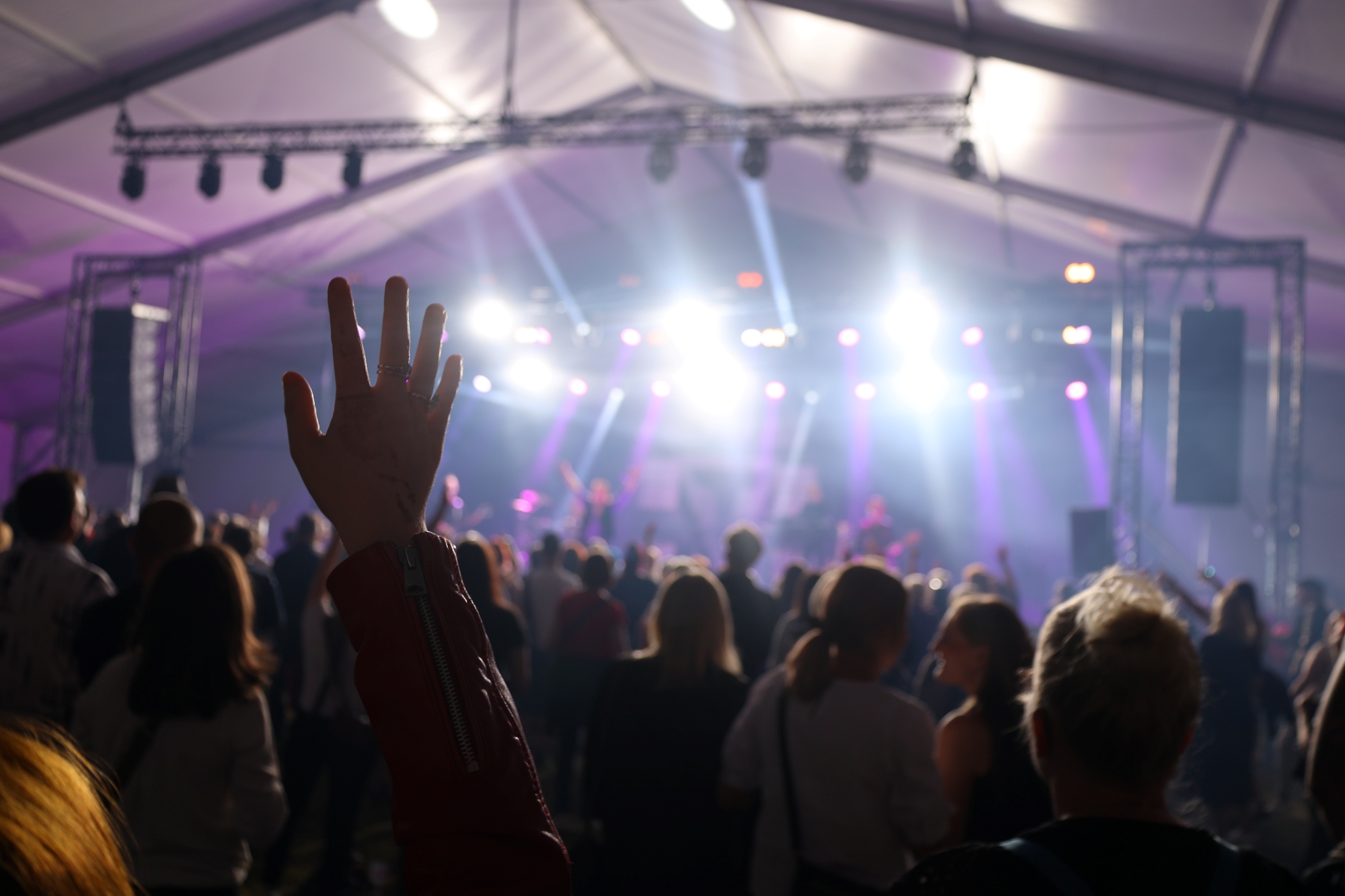 Ihmisiä seuraamassa konserttia juhlateltassa.